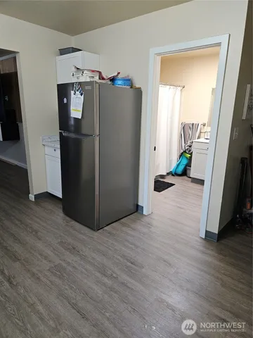 a kitchen with granite countertop a sink cabinets and wooden floor