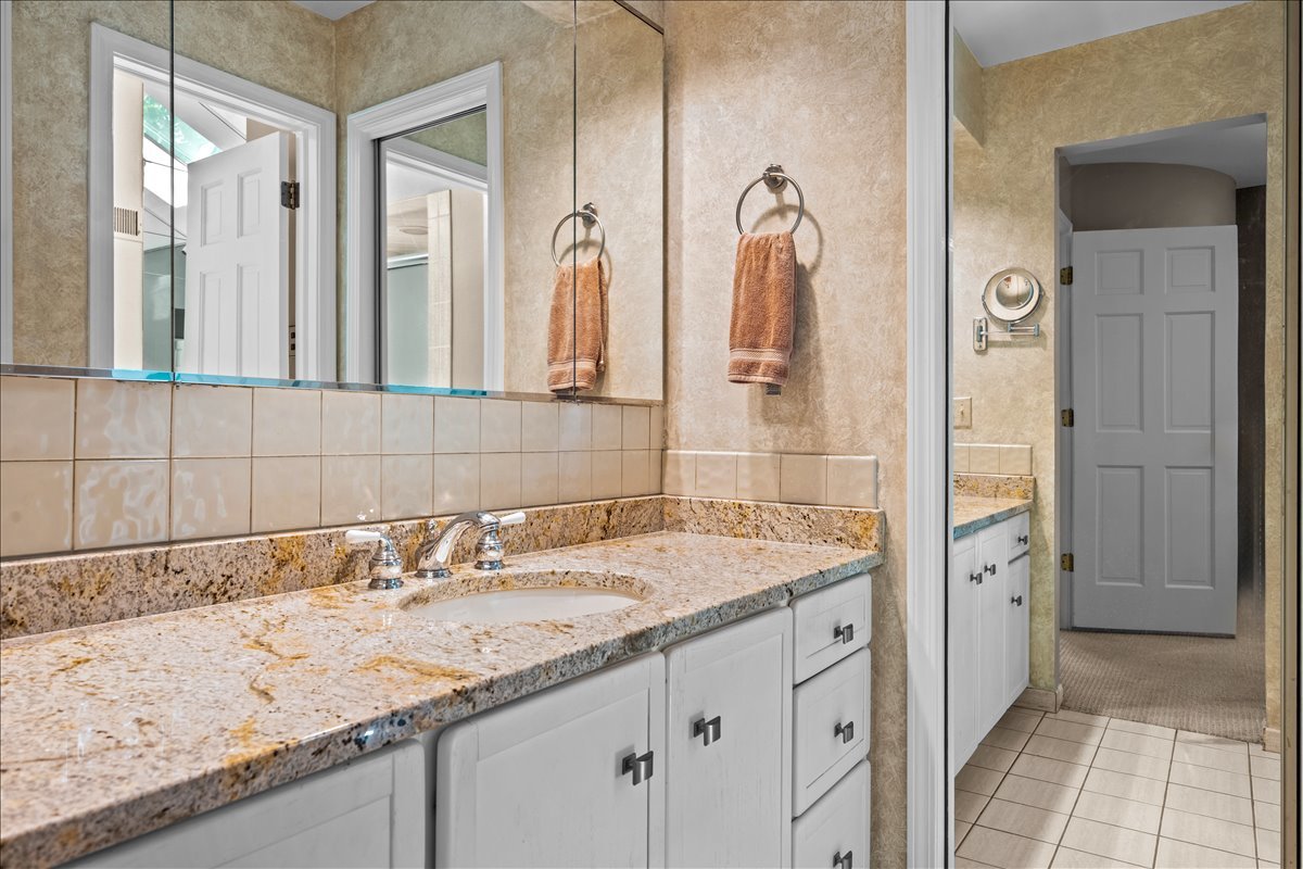 1985 Clavey Road Highland Park, IL 60035 - Photo 18 of 35 a bathroom with a granite countertop sink and a mirror