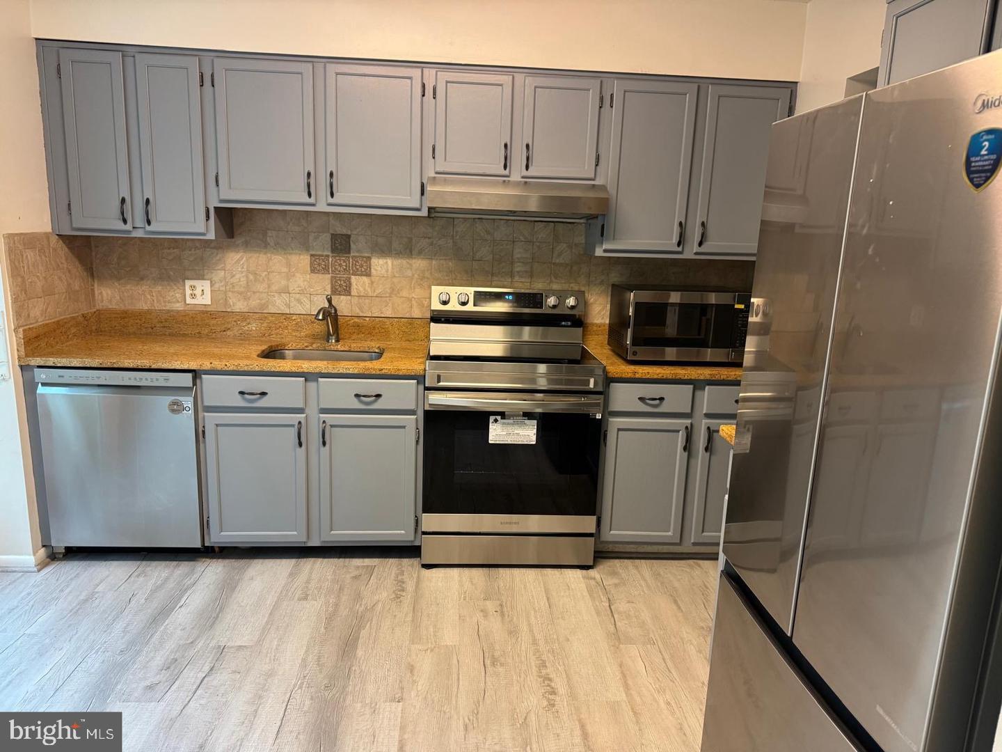 1631 Oak Spring Way Reston, VA 20190 - Photo 4 of 10 a kitchen with stainless steel appliances granite countertop a stove a sink and a refrigerator