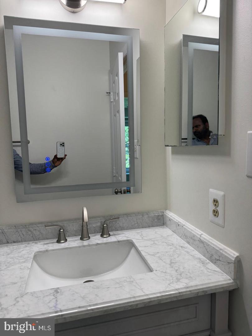 1631 Oak Spring Way Reston, VA 20190 - Photo 7 of 10 a bathroom with a sink and a mirror