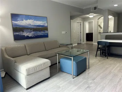 a living room with couches and a large mirror with wooden floor