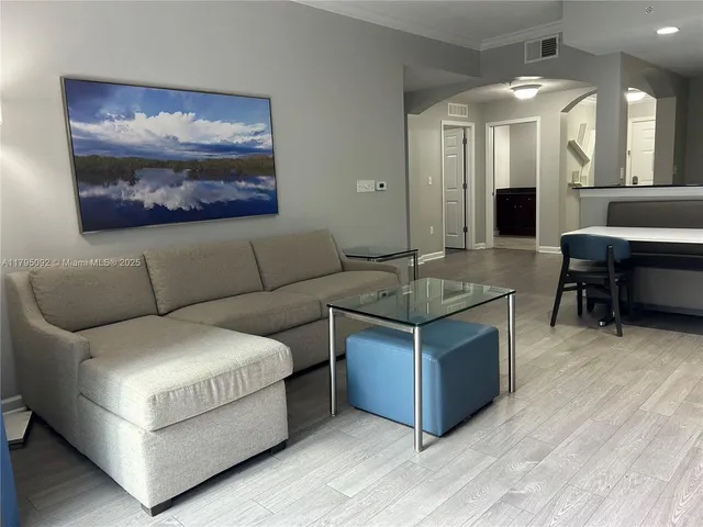 a living room with couches and a large mirror with wooden floor