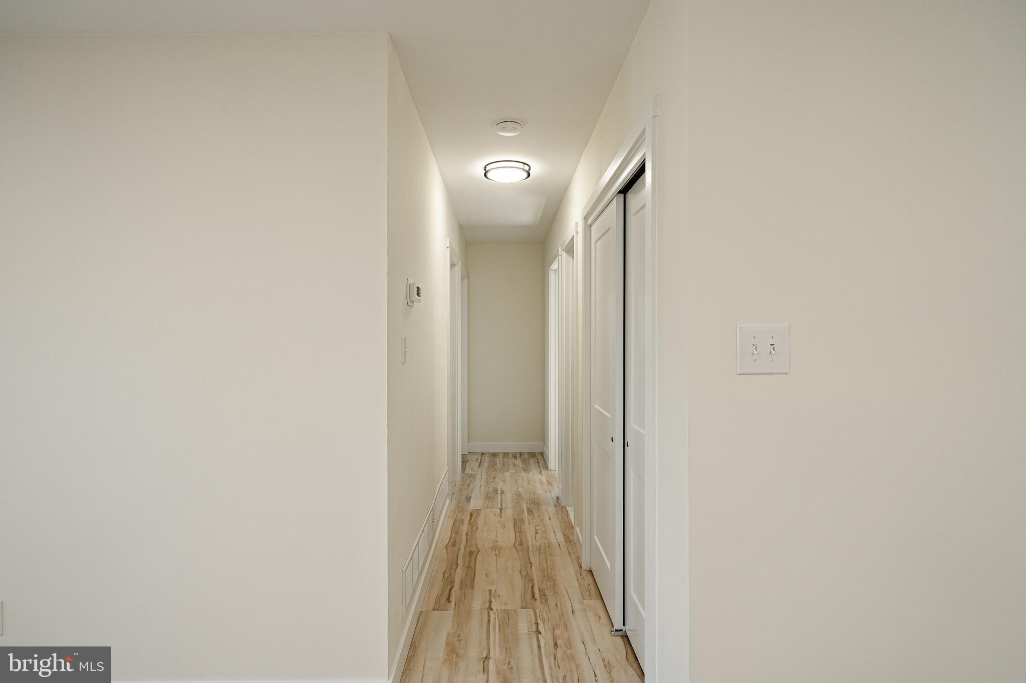 231 Laurel Bridge Road Landenberg, PA 19350 - Photo 12 of 57 a view of a hallway with wooden floor and a bathroom