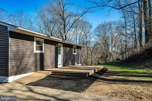 a view of a house with a yard and deck