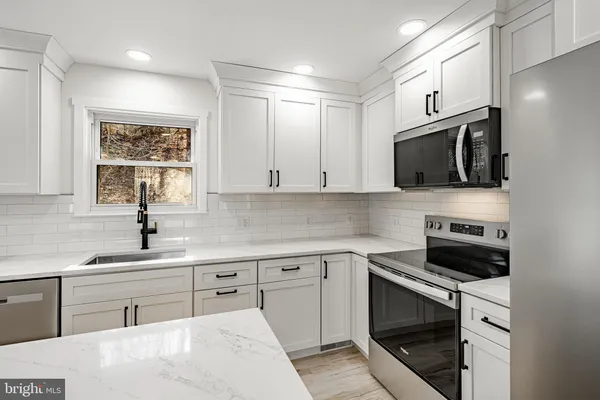 a kitchen with a sink stove and microwave