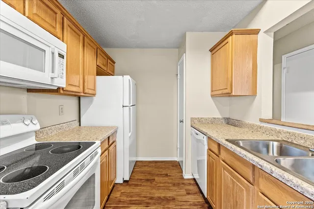 a kitchen with a sink stove top oven and refrigerator