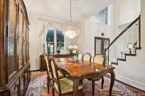 a dining room with furniture a chandelier and wooden floor