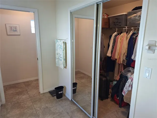 a view of walk in closet with clothes and shoes