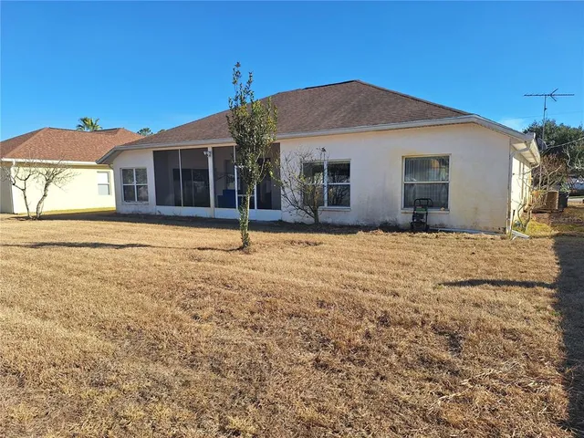 a front view of house with yard and trees in the background