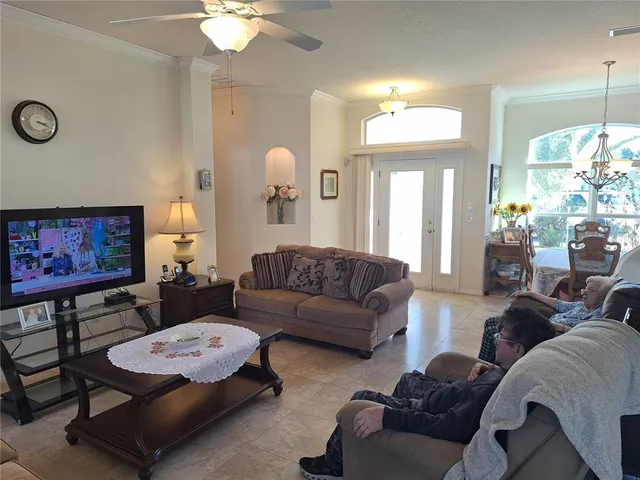 a living room with furniture a large window and a chandelier
