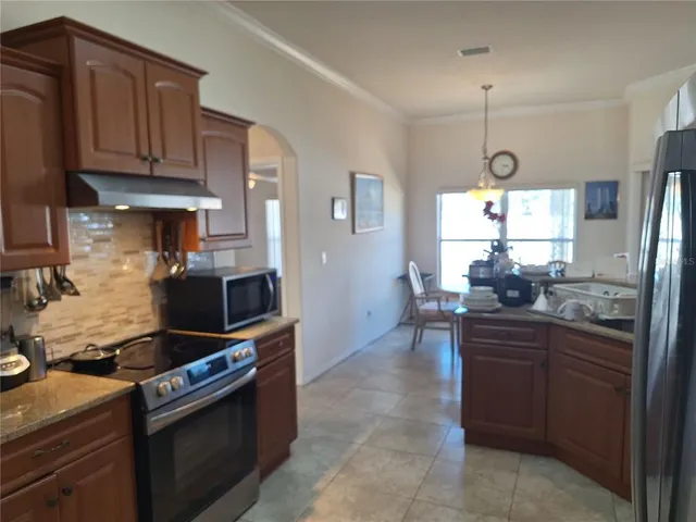 a kitchen with stainless steel appliances granite countertop a stove refrigerator sink and cabinets