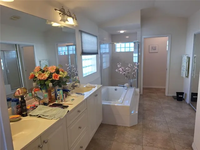 a spacious bathroom with a sink a large mirror and a shower