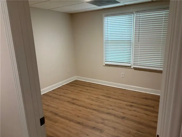 an empty room with wooden floor and a window