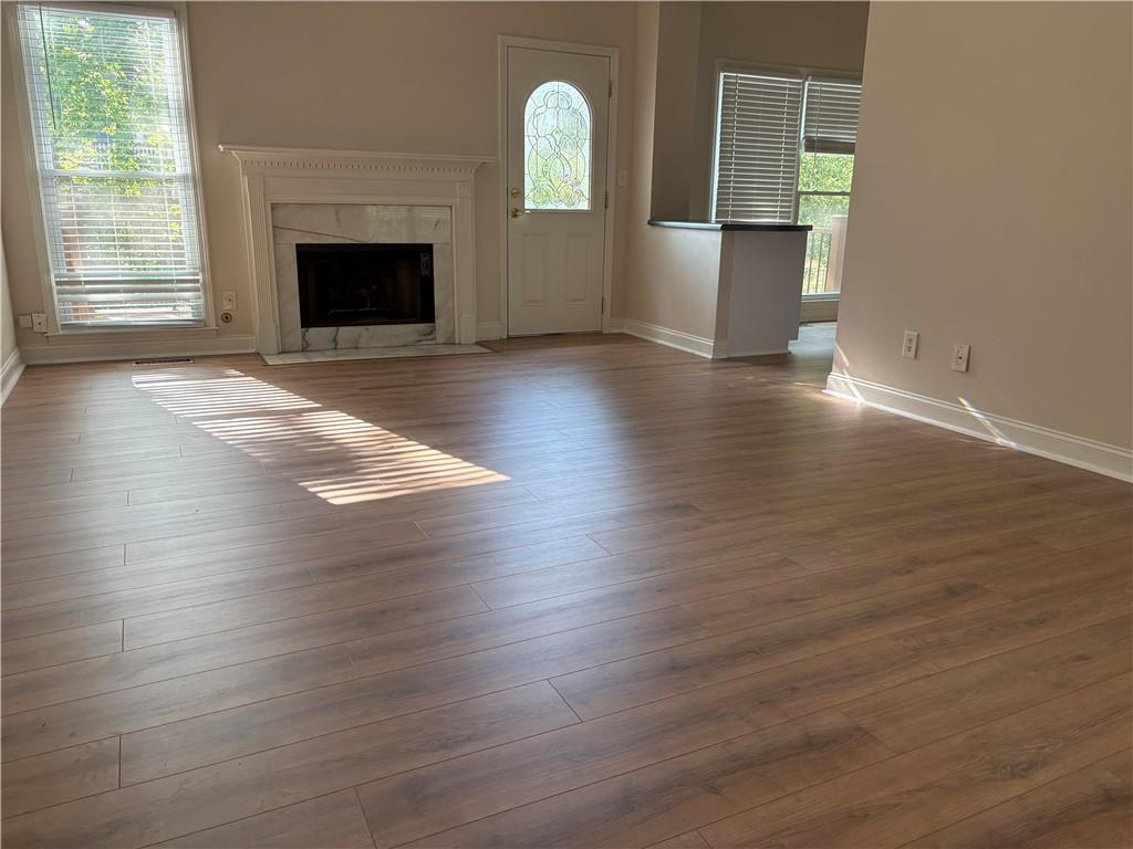 4747 Julian Way Acworth, GA 30101 - Photo 2 of 27 an empty room with wooden floor fireplace and windows