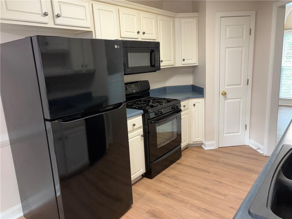 4747 Julian Way Acworth, GA 30101 - Photo 6 of 27 a kitchen with stainless steel appliances wooden cabinets and a stove a oven