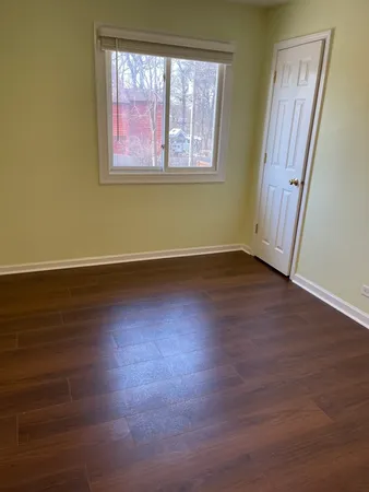 a view of a room with wooden floor and window