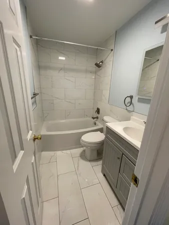 a bathroom with a sink a toilet a mirror a vanity and bathtub