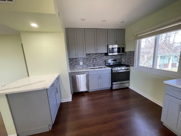 a kitchen with stainless steel appliances a stove a sink and a refrigerator