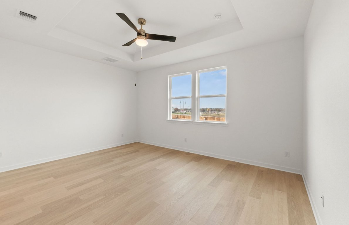 408 Sullivan Way Elgin, TX 78621 - Photo 11 of 22 an empty room with a ceiling fan and windows