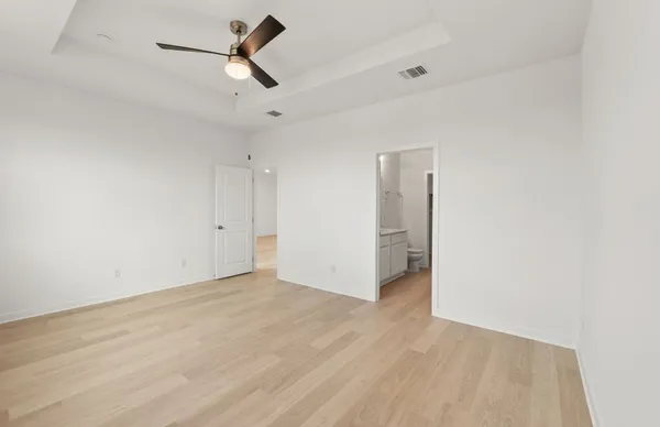 an empty room with a ceiling fan and windows