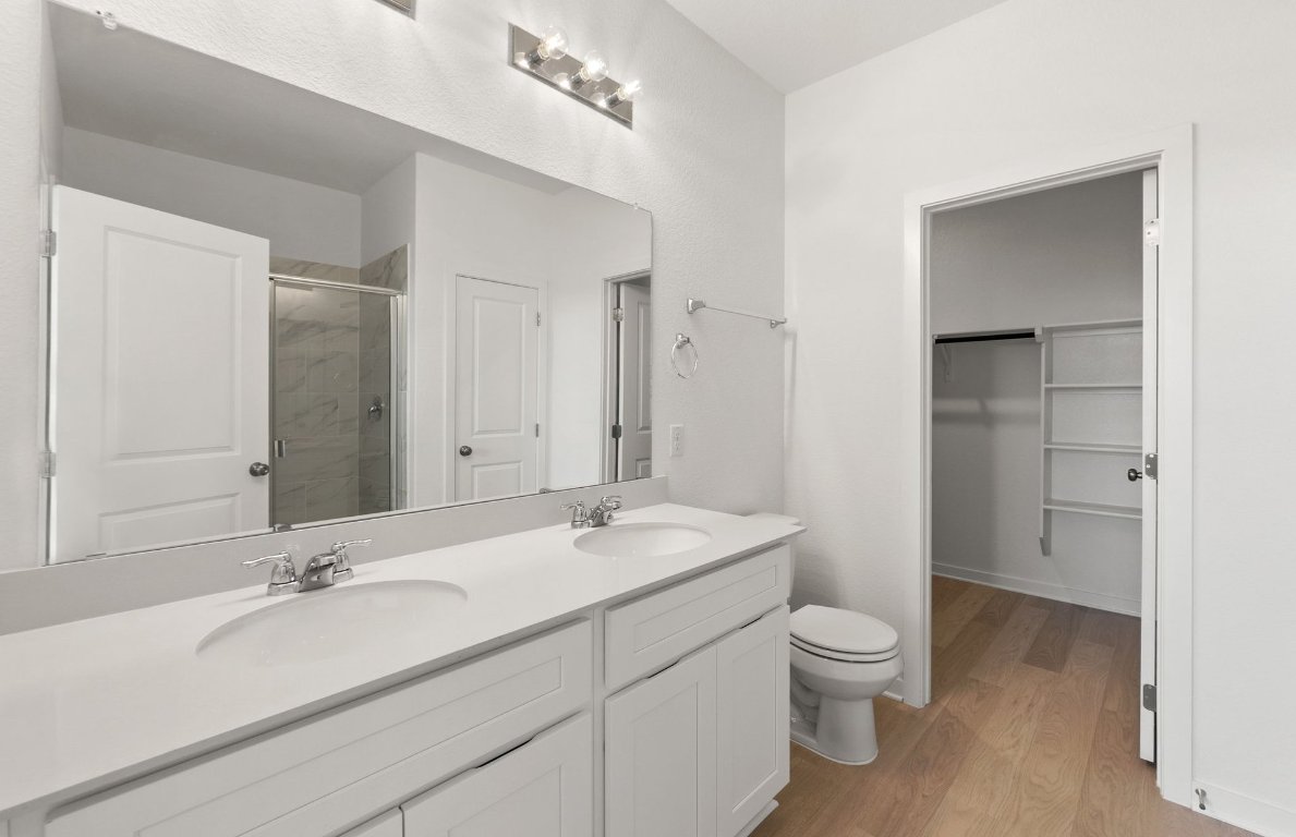 408 Sullivan Way Elgin, TX 78621 - Photo 14 of 22 a bathroom with a granite countertop sink a toilet and a large mirror