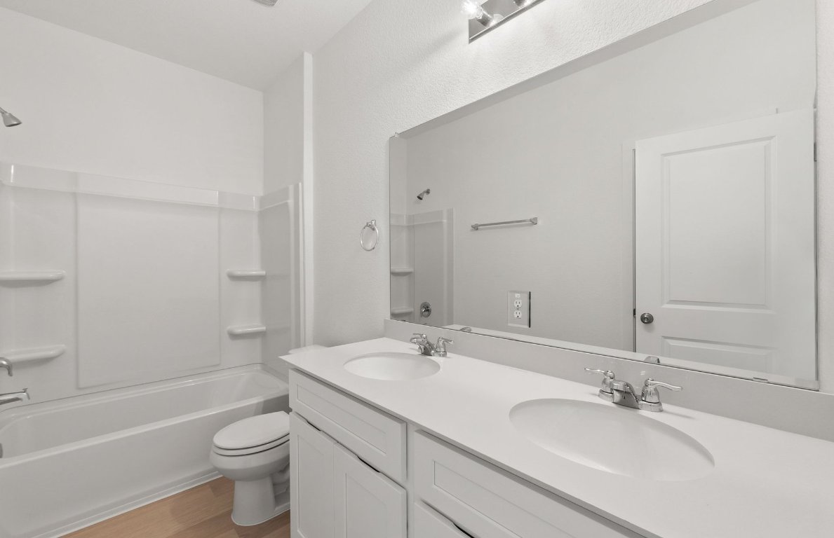 408 Sullivan Way Elgin, TX 78621 - Photo 19 of 22 a bathroom with a granite countertop sink a toilet and bathtub