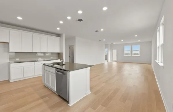 a kitchen with sink a microwave and cabinets