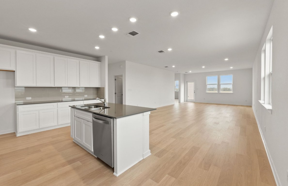 408 Sullivan Way Elgin, TX 78621 - Photo 5 of 22 a kitchen with stainless steel appliances granite countertop a stove and a sink