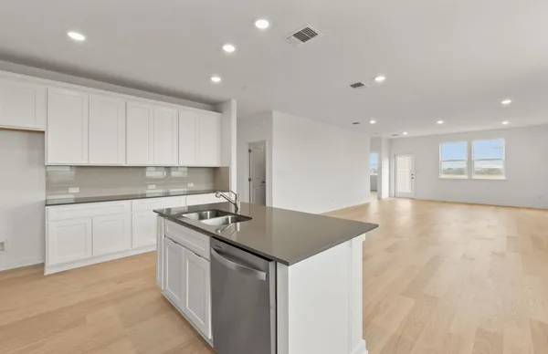a kitchen that has a sink and a stove top oven