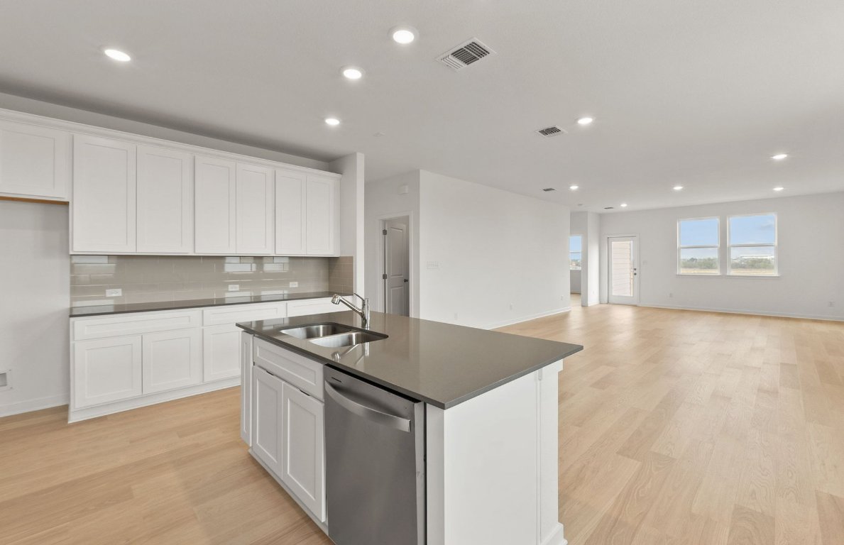408 Sullivan Way Elgin, TX 78621 - Photo 7 of 22 a kitchen that has a sink and a stove in it