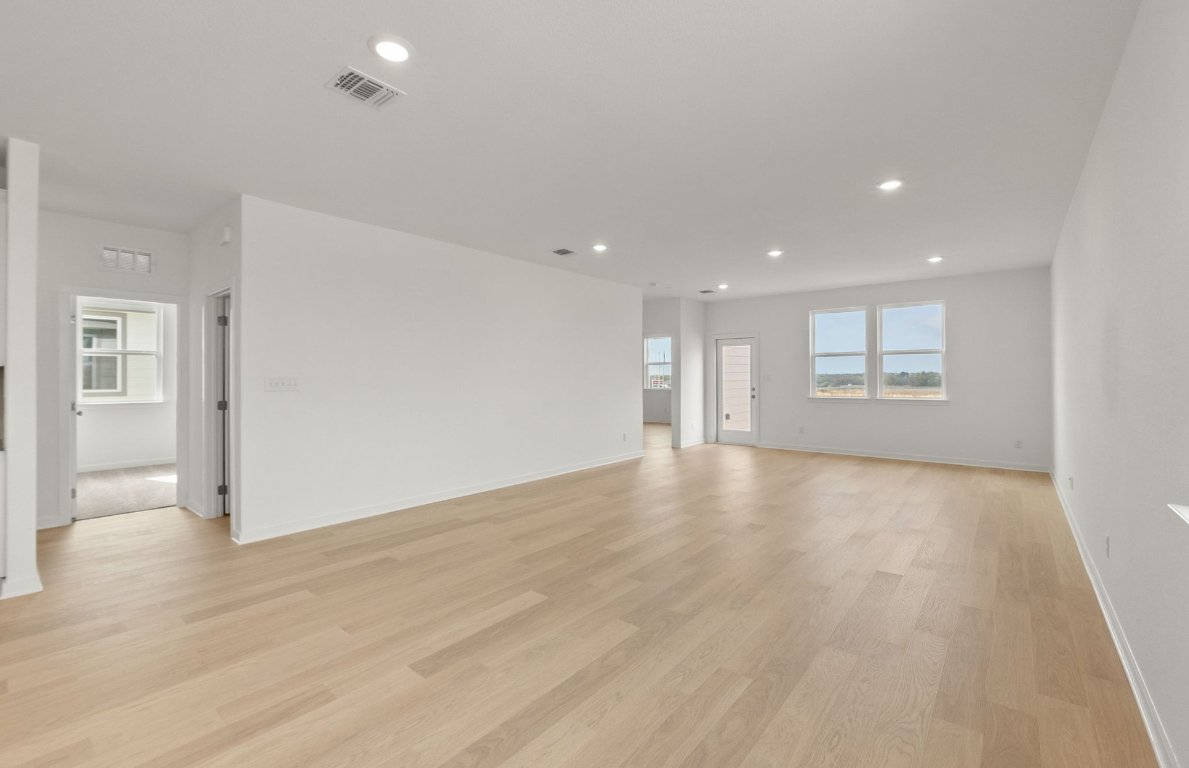 408 Sullivan Way Elgin, TX 78621 - Photo 8 of 22 an empty room with wooden floor and windows