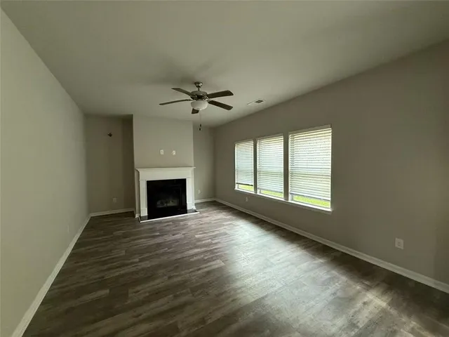 a view of an empty room with a fireplace and a window