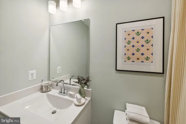 a bathroom with a sink mirror and toilet