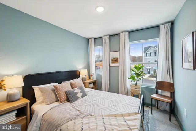 a bedroom with a bed table and a potted plant