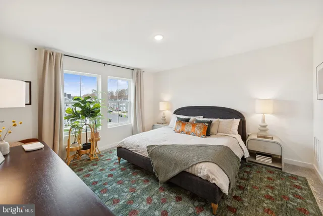 a bedroom with a bed and a large window