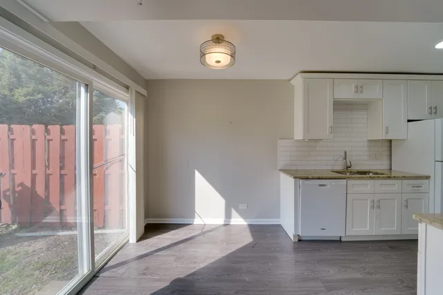 a view of kitchen with granite countertop cabinets and sink