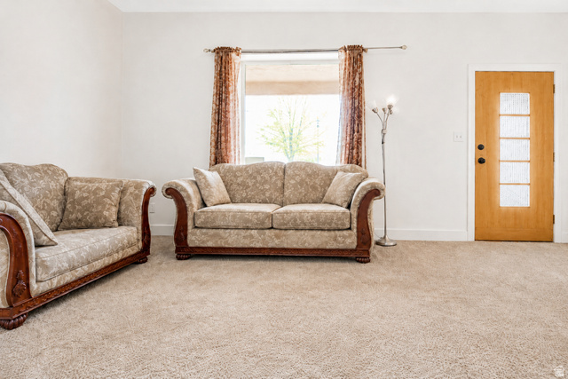 69 South Main Street Manti, UT 84642 - Photo 26 of 44 Spacious interior featuring neutral carpeting, a large window with natural light, and a light wood-finish entry door with frosted glass panels