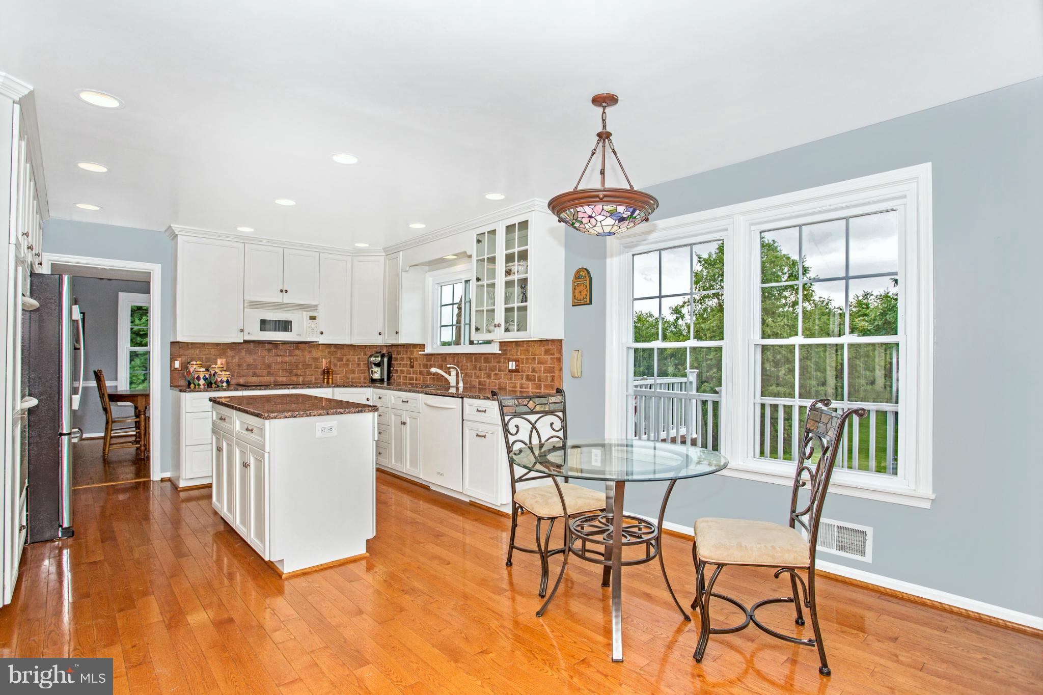 17610 Conoy Road Barnesville, MD 20838 - Photo 14 of 30 a kitchen with stainless steel appliances granite countertop a stove a refrigerator a kitchen island with a dining table and chairs