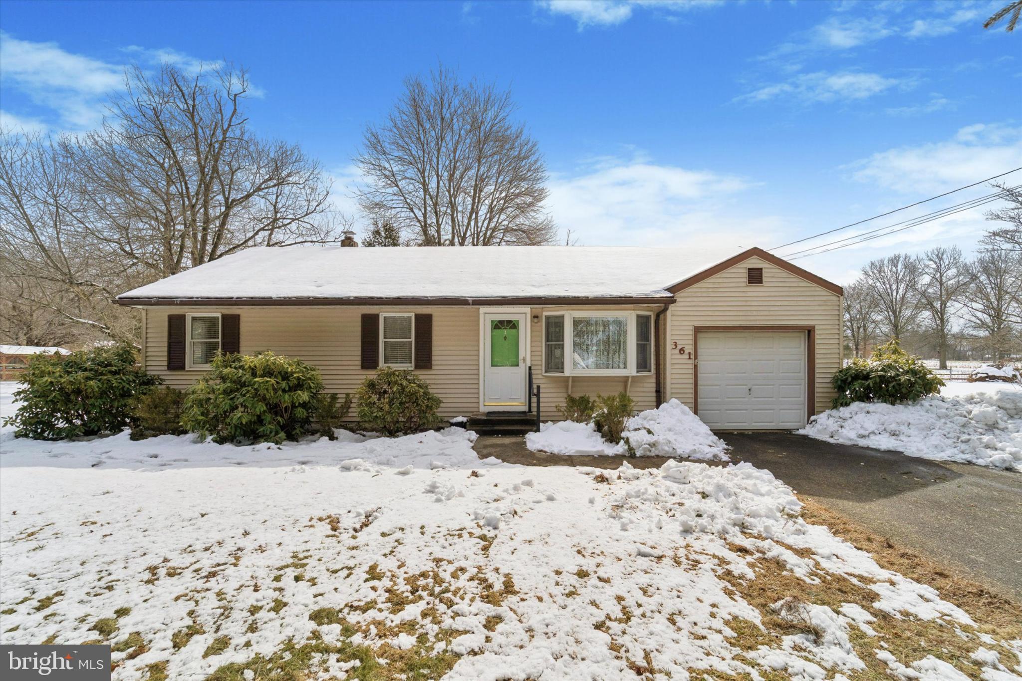 a front view of a house with a yard covered in snow