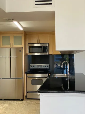 a kitchen with a refrigerator and a stove