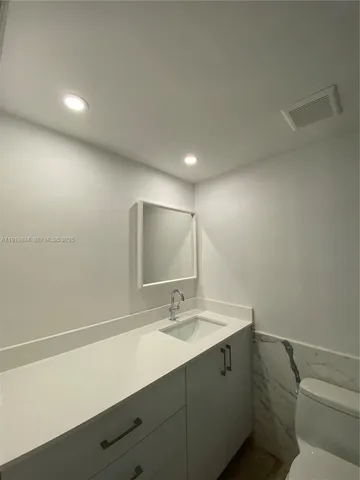 a bathroom with a sink a toilet and a mirror