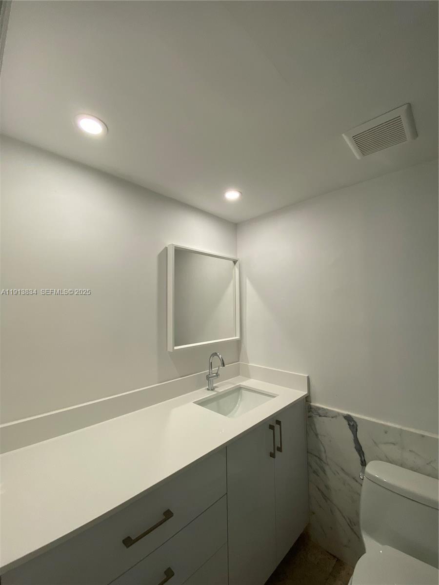 177 Ocean Ln Drive, Unit 505 Key Biscayne, FL 33149 - Photo 8 of 26 a bathroom with a sink a toilet and a mirror