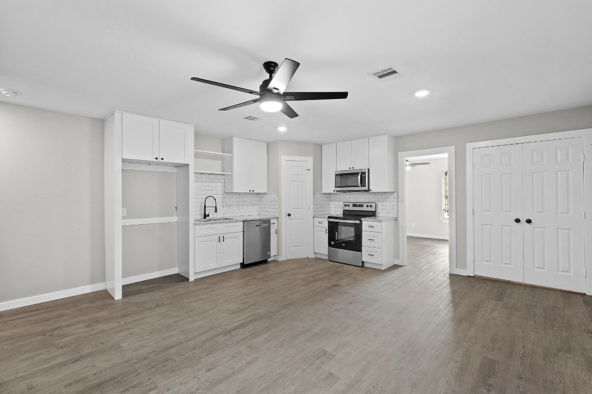 a kitchen with white cabinets and stainless steel appliances