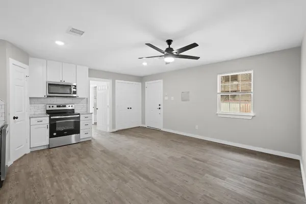 a view of a kitchen with a stove microwave and cabinets