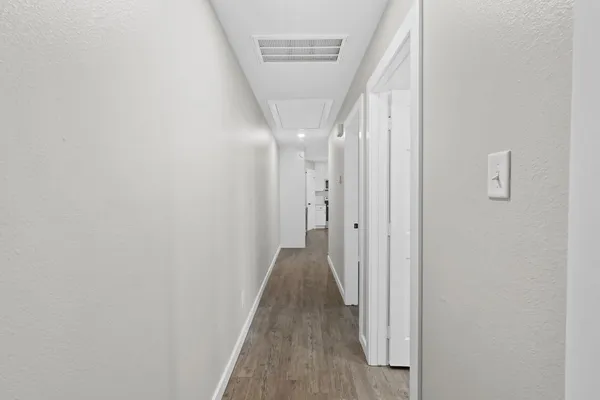 a view of a hallway with wooden floor and entryway