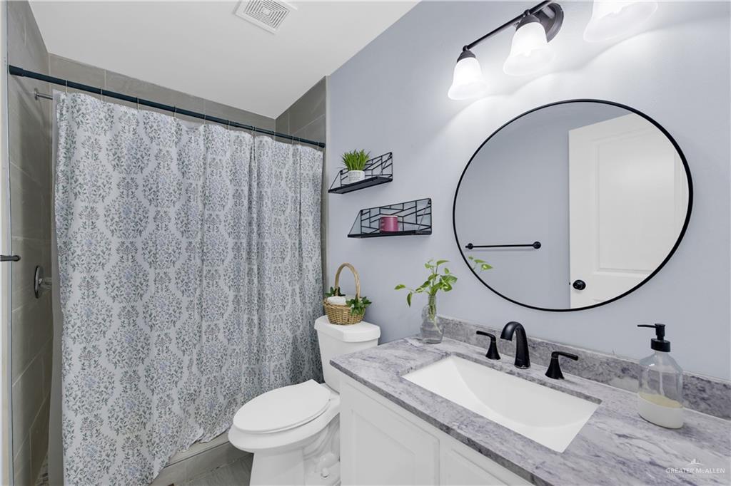 10514 Crocosmia Lane Edcouch, TX 78538 - Photo 14 of 22 a bathroom with a granite countertop sink mirror and toilet