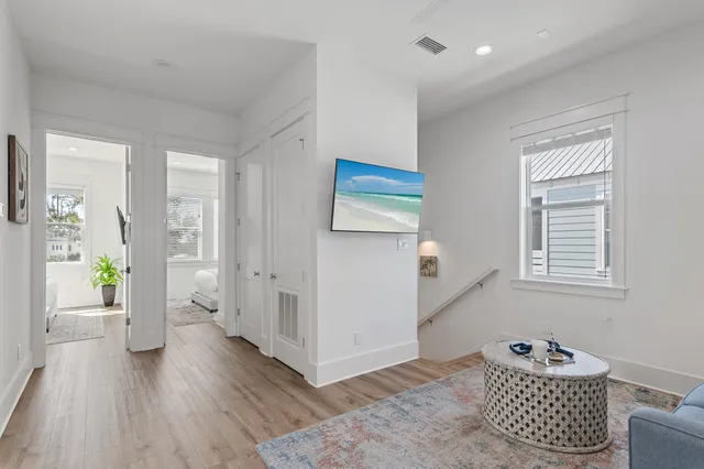a large white bed sitting in a bedroom next to a window