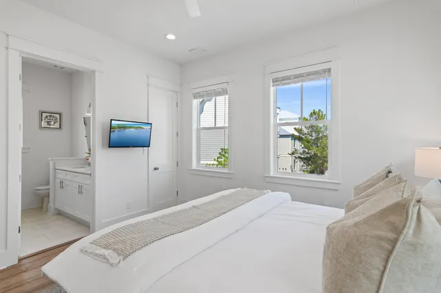 a bedroom with a large bed and a potted plant