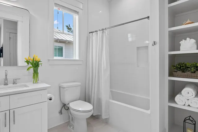 a large bed sitting in a bedroom next to a window and a potted plant