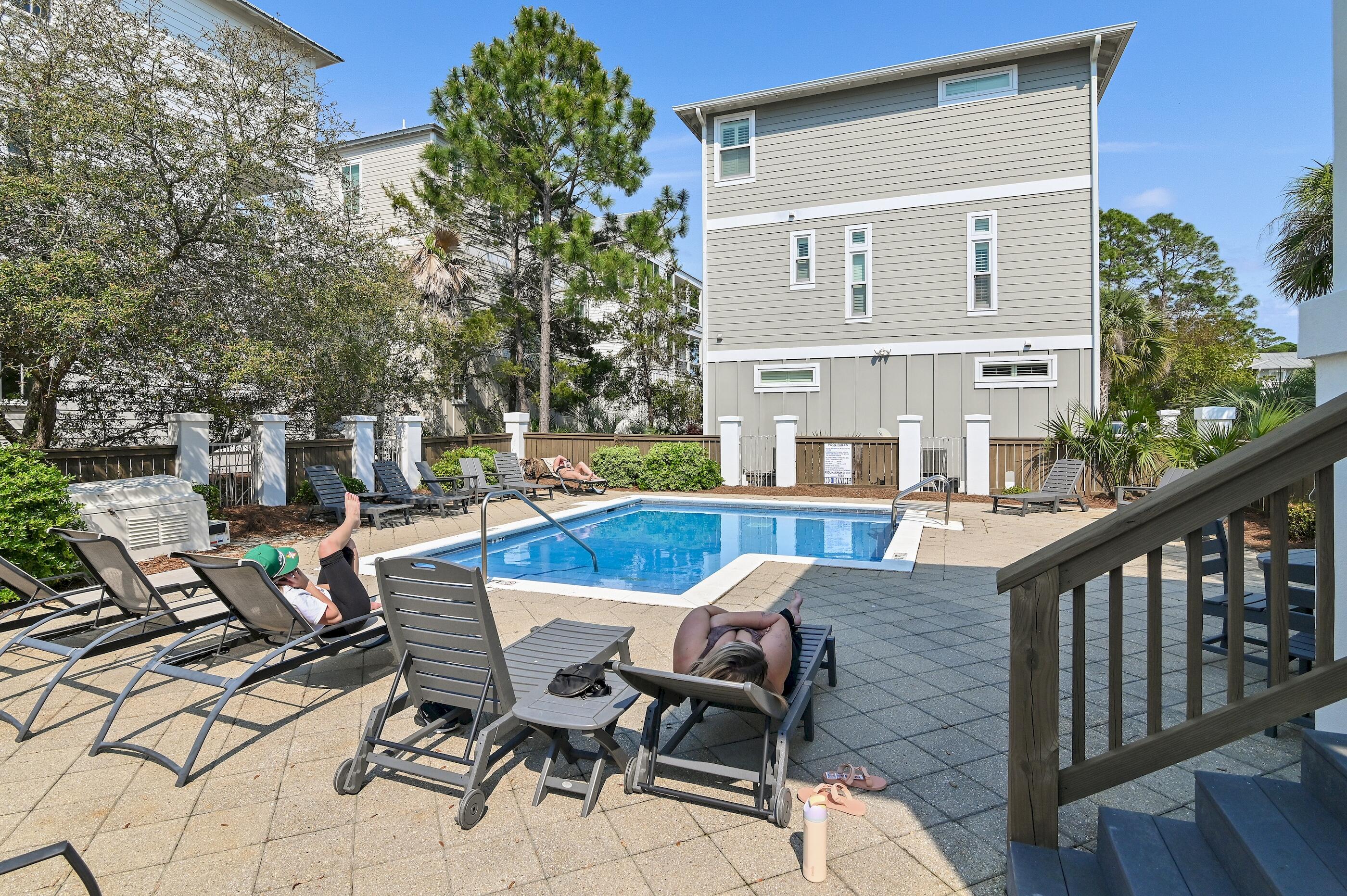 63 Sawgrass Lane Santa Rosa Beach, FL 32459 - Photo 31 of 51 a view of a patio with table and chairs and potted plants with wooden floor and fence